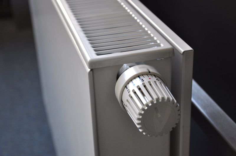 Radiateur à panneau blanc avec son robinet thermostatique gradué, vu de près
